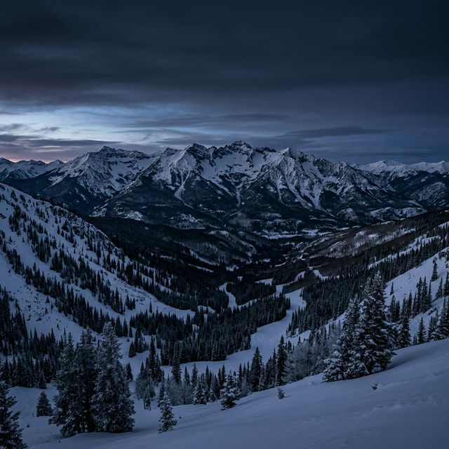 Panoramic view of snow-covered mountains at Beaver Creek, Colorado with a starlit night sky